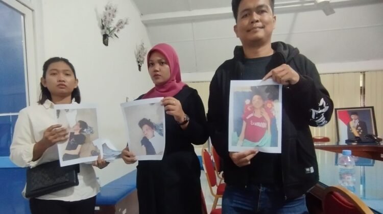 Ega Prasetya (tengah) memegang foto abang kandungnya Argo Prasetiyo, yang meninggal dunia di Kamboja, saat melapor ke kantor Badan Pelayanan Perlindungan Pekerja Migran Indonesia (BP3MI) Sumatera Utara, Selasa (14/10/2025).(KOMPAS.com/CRISTISON SONDANG PANE)